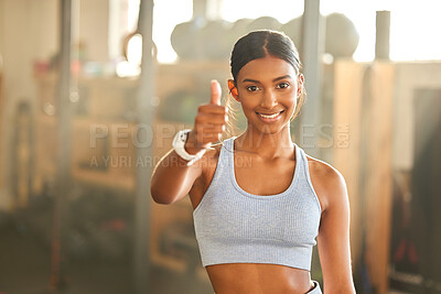 Buy stock photo Portrait of a fit young woman showing thumbs up in a gym