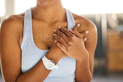 Buy stock photo Shot of an unrecognisable woman clutching her chest in pain at a gym