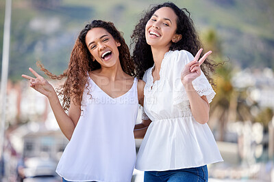 Buy stock photo Shot of two young women making peace gestures during a fun day outdoors