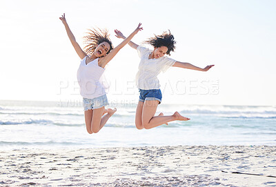 Buy stock photo Shot of two young women jumping for joy at the beach