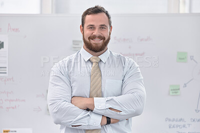 Buy stock photo Portrait of a confident young businessman standing with his arms crossed in front of a whiteboard in an office