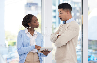Buy stock photo Shot of two business colleagues using a digital tablet while having a discussion