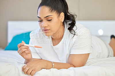 Buy stock photo Shot of a young woman taking a pregnancy test at home