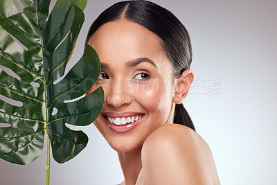 Buy stock photo Studio shot of a beautiful young woman posing with a leaf against a grey background