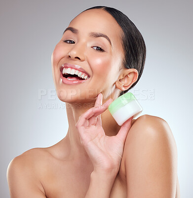 Buy stock photo Studio portrait of a beautiful young woman holding a beauty product against a grey background