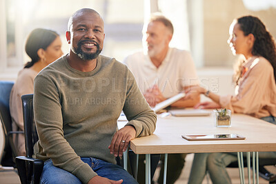 Buy stock photo Portrait of a mature businessman at the office sitting in front of his colleagues having a meeting in the background