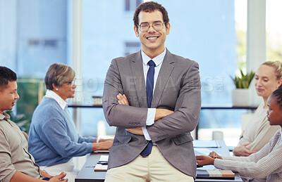 Buy stock photo Shot of a businessman standing with her arms crossed in the boardroom with her colleagues in the background