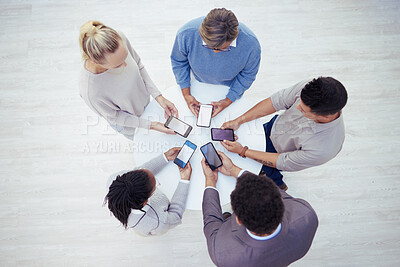 Buy stock photo Overhead shot of a group of businesspeople using their phones in a office