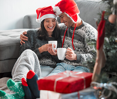 Buy stock photo Shot of a young couple drinking coffee while celebrating Christmas at home