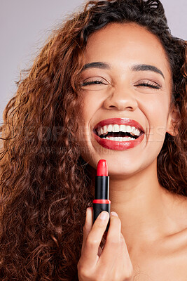 Buy stock photo Shot of a young woman applying lipstick against a grey background