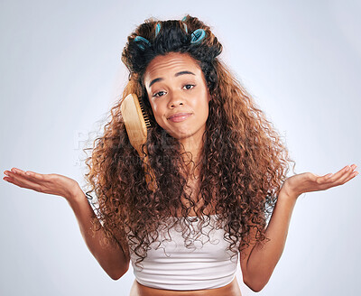 Buy stock photo Cropped portrait of an attractive young woman struggling with knotted hair in studio against a grey background