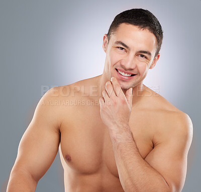 Buy stock photo Studio shot of a handsome young man sitting shirtless against a grey background
