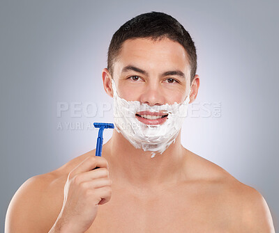 Buy stock photo Shot of a man with shaving foam and his face while holding a razor