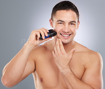 Buy stock photo Shot of a handsome young man shaving his facial hair