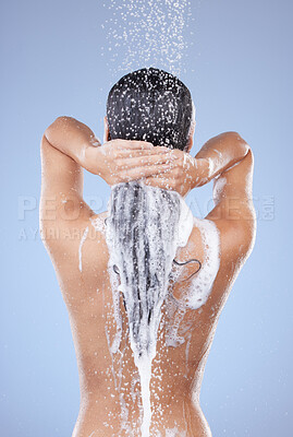 Buy stock photo Shot of an unrecognizable woman washing her hair in the shower against a blue background