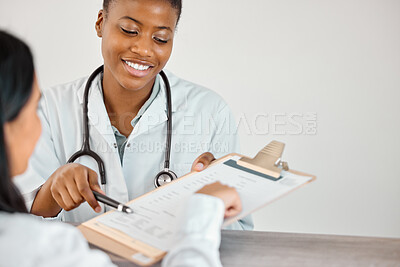 Buy stock photo Shot of a young doctor and patient going through paperwork at a clinic
