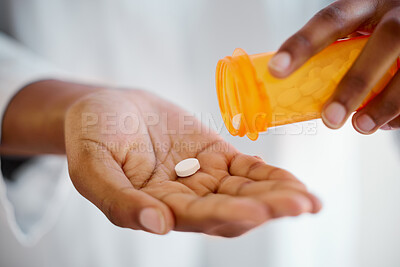 Buy stock photo Shot of an unrecognizable person taking tablets at home