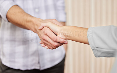 Buy stock photo Cropped shot of two unrecognizable businesspeople shaking hands while standing in an office
