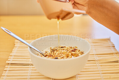 Buy stock photo Cropped shot of an unrecognisable man putting honey into his morning cereal at home