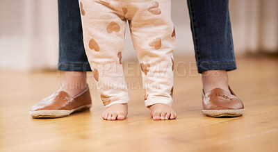 Buy stock photo Shot of a unrecognizable mom helping her baby learning to walk at home