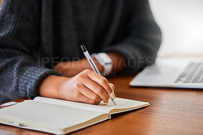Buy stock photo Cropped shot of an unrecognizable female entrepreneur writing in her notebook while working at home