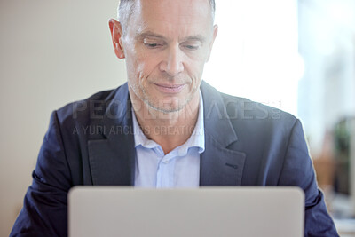 Buy stock photo Shot of a mature businessman using a laptop in an office at work