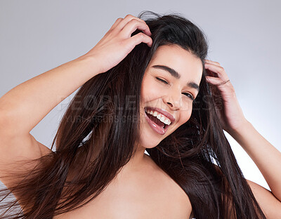 Buy stock photo Studio portrait of an attractive young woman winking against a grey background