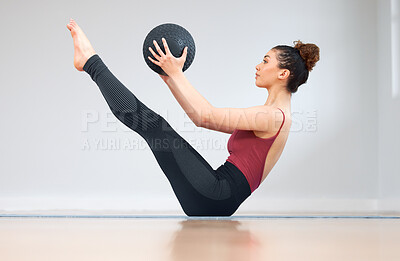Buy stock photo Shot of a young woman doing core exercises using a medicine ball