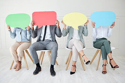 Buy stock photo Shot of a group of unrecognizable businesspeople holding speech bubbles while sitting in line against a grey background
