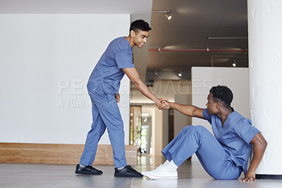 Buy stock photo Shot of a young male doctor consoling a coworker at work