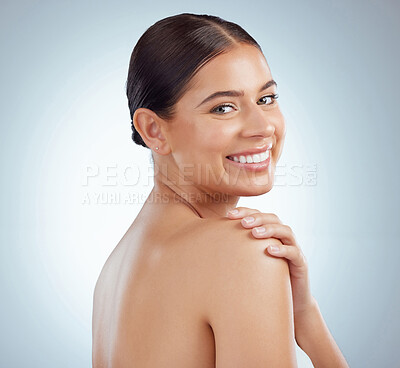 Buy stock photo Portrait of beautiful woman with smooth glowing skin and copyspace posing topless and touching shoulder. Smiling caucasian model isolated against a grey studio background with healthy skincare routine