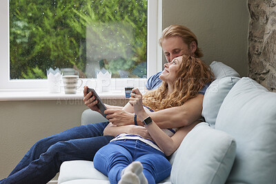 Buy stock photo A couple relaxing on the couch together using a credit card to make online purchases