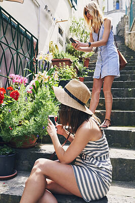 Buy stock photo Two friends taking photos of pot flowers using smartphone for social media while on adventure travel vacation