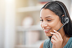 Young woman wearing a headset giving a customer great service in a call center. Hispanic businesswoman training to work in a call center. Call center operator providing it support through headphones