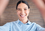 Closeup portrait of a cheerful mixed race young woman standing in an office taking a selfie 
