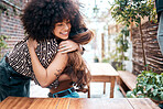 Two diverse mixed race friends excited to meet up at a cafe. African American with a beautiful curly afro hugging her friend and smiling while getting together for a catch up and lunch 