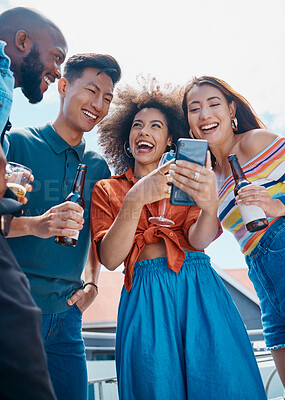 Buy stock photo A group of diverse young cheerful friends standing outside together and using a cellphone for selfies and social media. Smiling men and women being social and celebrating on a weekend party 