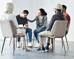 Man having a breakdown during group therapy session about addiction. Friend giving support to depressed crying mixed race man at group psychological treatment