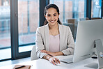 Portrait of mixed race businesswoman sitting alone in her office and using a computer. Smiling hispanic professional feeling confident while using a laptop. Leading entrepreneurs in business