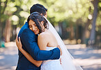 Loving newlywed couple hugging each other. Bride and groom embracing each other feeling loved standing together against nature background