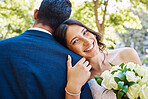 Portrait of beautiful mixed race bride holding bouquet while standing with her groom and leaning on his shoulder in nature