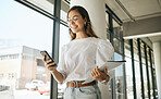Happy business woman texting on smartphone holding file and walking in modern office. Smiling female entrepreneur using mobile app or browsing social media