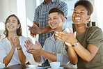 Group of cheerful diverse businesspeople clapping hands in support during a meeting together at work. Happy business professionals giving a coworker an applause in a workshop