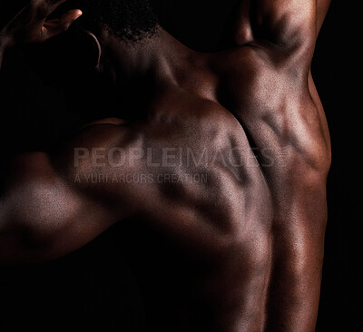 Buy stock photo Closeup rearview shot of the back of a black african american man posing in studio isolated against a black background. The human body in masculine and muscular form. A show of strength and dedication