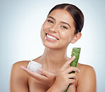 Portrait of smiling beautiful woman using aloe vera in skincare routine. Caucasian model isolated against grey studio background and posing with copyspace. Organic plants for hydration and moisture