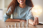 A lineup of coins illustrating a graph and a black woman holding a lightbulb. The growth of a business leads to success and innovation. Any startup requires money and investments to generate ideas.