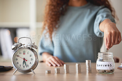 Buy stock photo Young african american woman money putting coins into a glass savings jar at home. Mixed race person counting coins while financial planning in her living room. Investing and thinking about the future