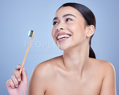 Buy stock photo A smiling mixed race young woman with glowing skin posing against blue copyspace background while brushing her teeth for fresh breath. Hispanic model using toothpaste to prevent a cavity