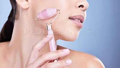 Buy stock photo Closeup of a beautiful mixed race woman using a rose quartz derma roller during a selfcare grooming routine. Young hispanic woman using anti ageing tool to prevent wrinkles