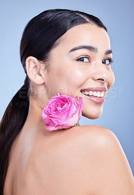 Buy stock photo Studio portrait of a beautiful mixed race woman posing with a flower. Young hispanic using an organic skincare treatment against a blue copyspace background